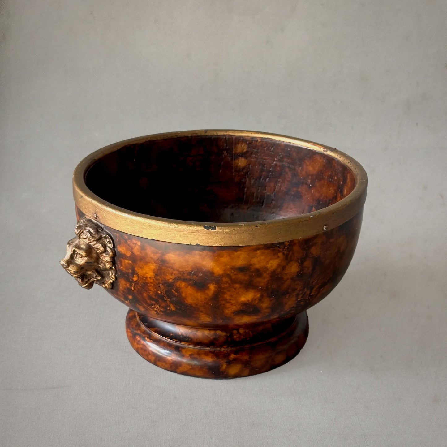 19th-century English faux tortoiseshell bowl with brass rim and lion head handles, side view