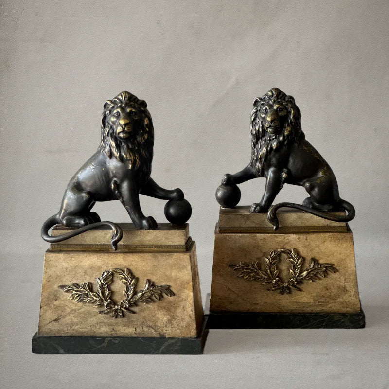 Pair of bronze lion sculptures on faux-painted plinths with laurel wreaths, English neoclassical style, circa 1820, 2