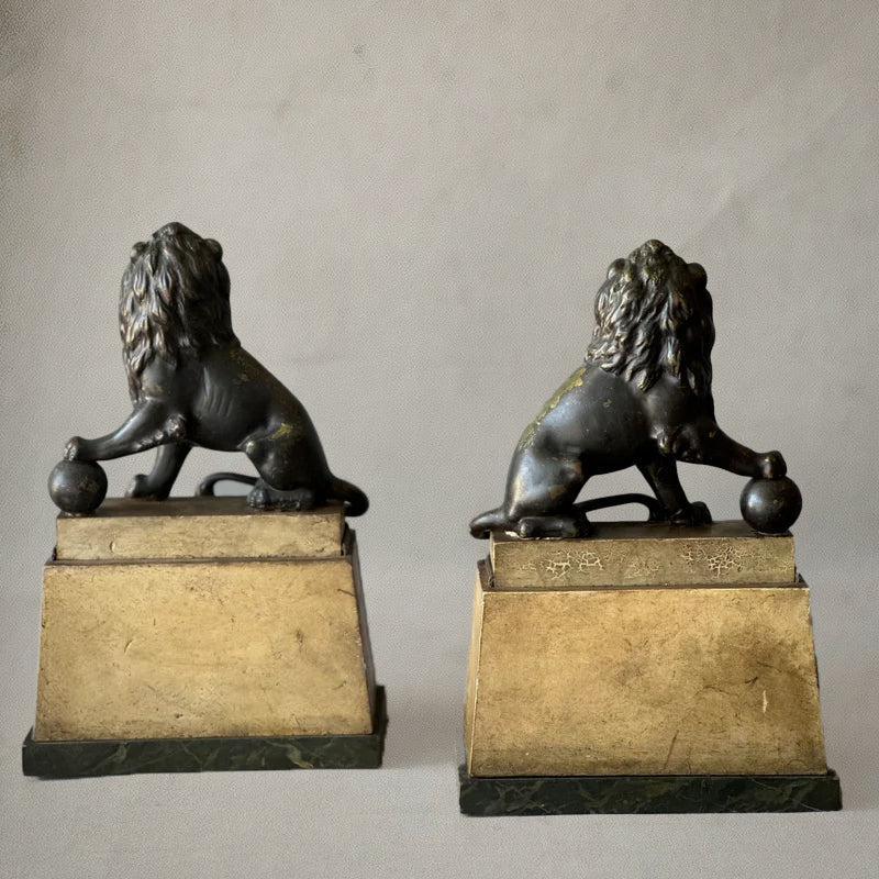 Pair of bronze lion sculptures on faux-painted plinths with laurel wreaths, English neoclassical style, circa 1820, back