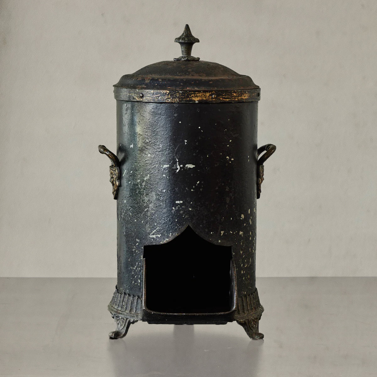 Antique English coal scuttle in black painted tin with finial lid and claw feet, circa 1860