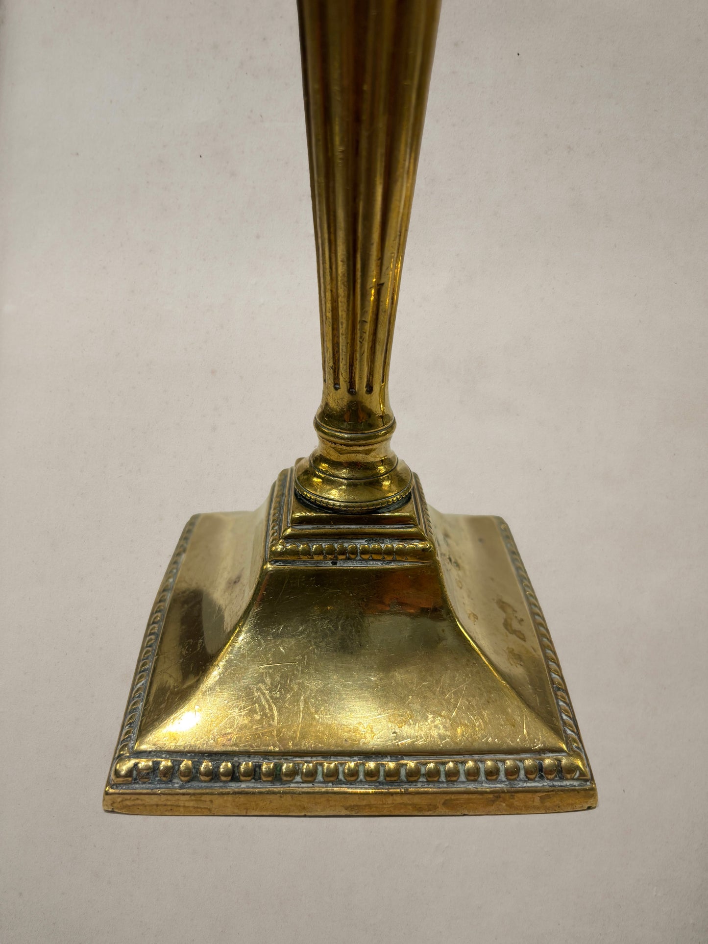 Pair of Georgian brass candlesticks with fluted columns and beaded square bases