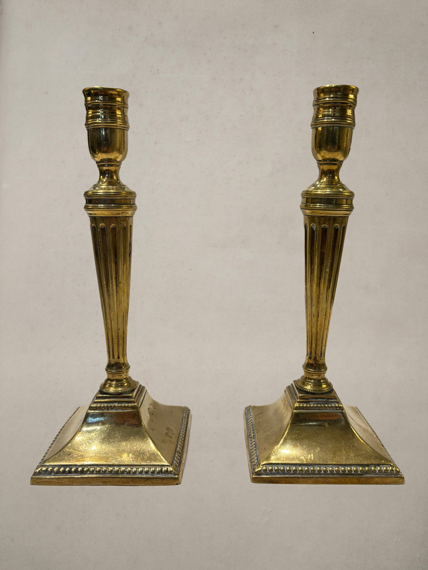 Pair of Georgian brass candlesticks with fluted columns and beaded square bases