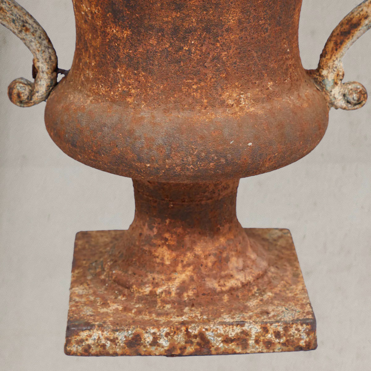 Pair of antique Italian iron urns with scrolled handles and rustic patina