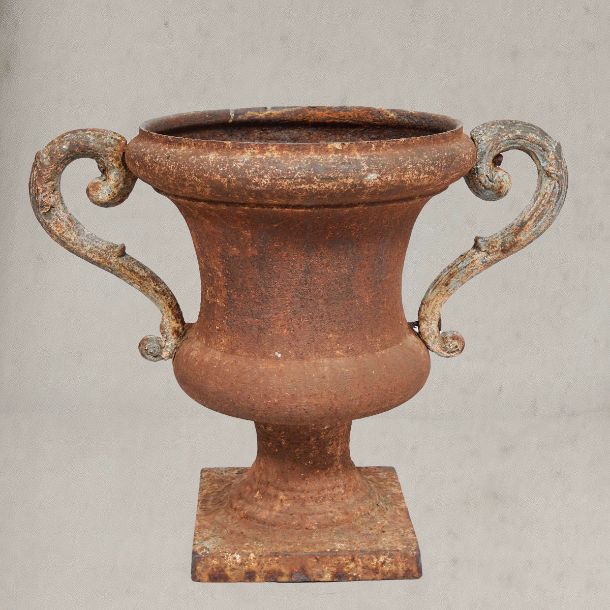 Pair of antique Italian iron urns with scrolled handles and rustic patina
