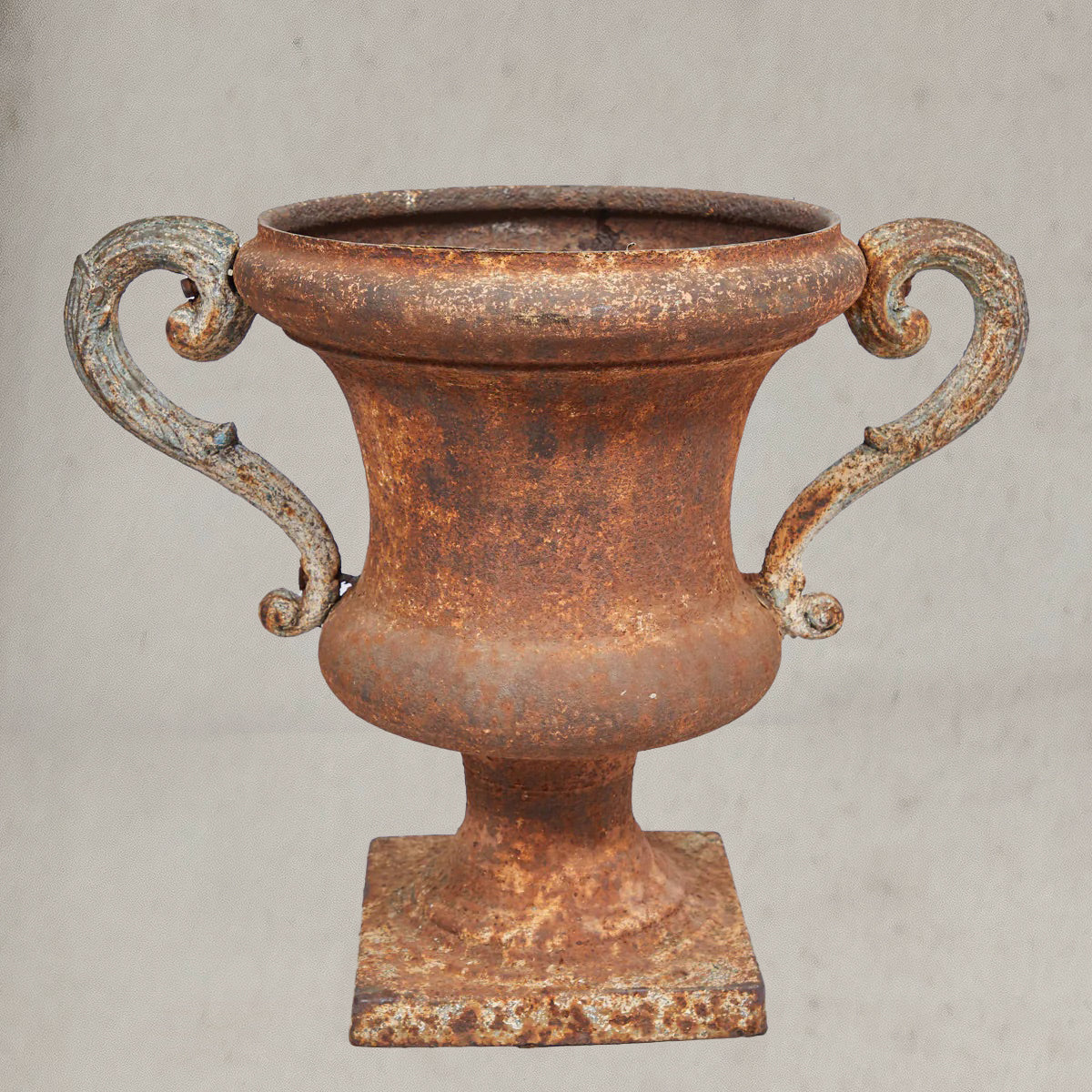Pair of antique Italian iron urns with scrolled handles and rustic patina