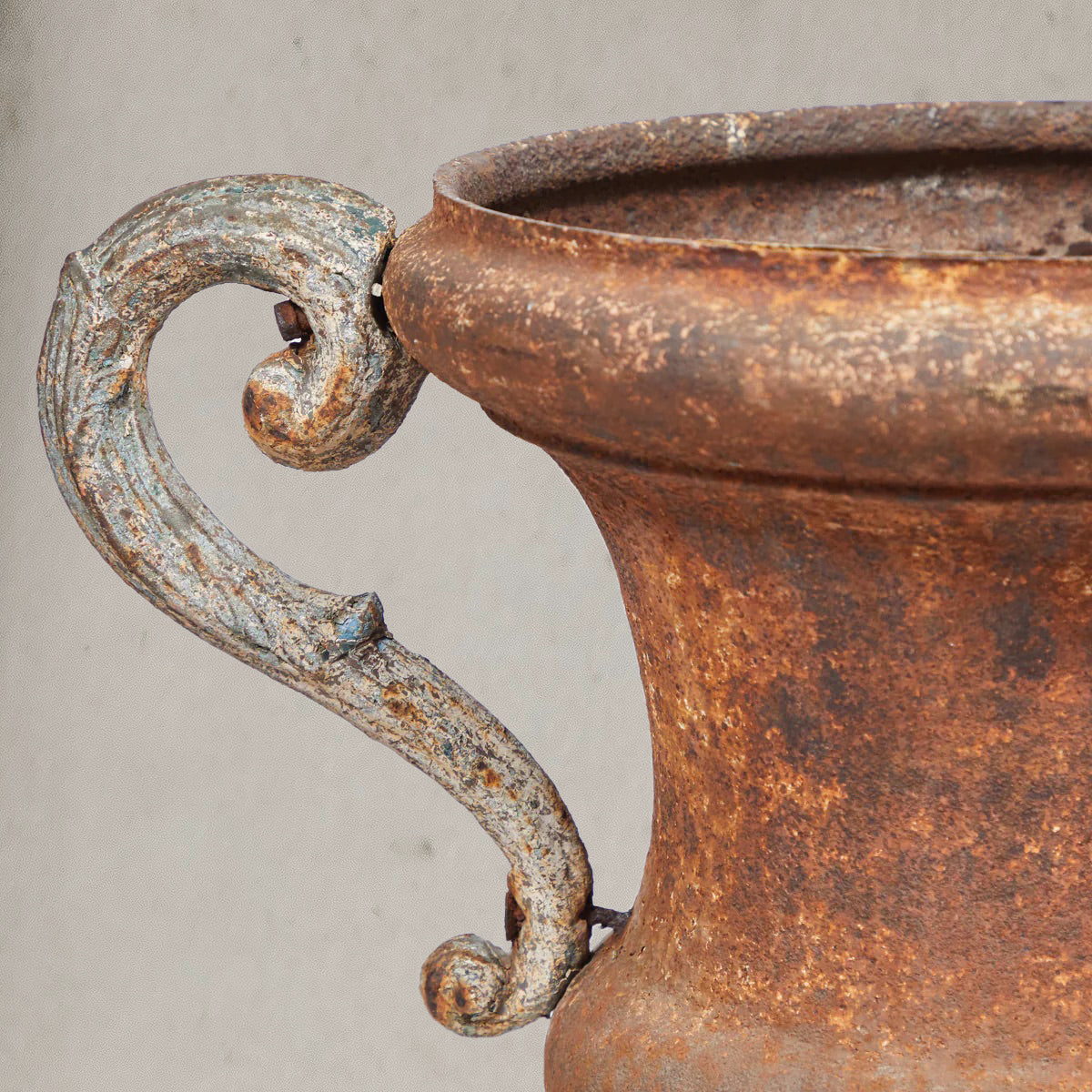 Pair of antique Italian iron urns with scrolled handles and rustic patina