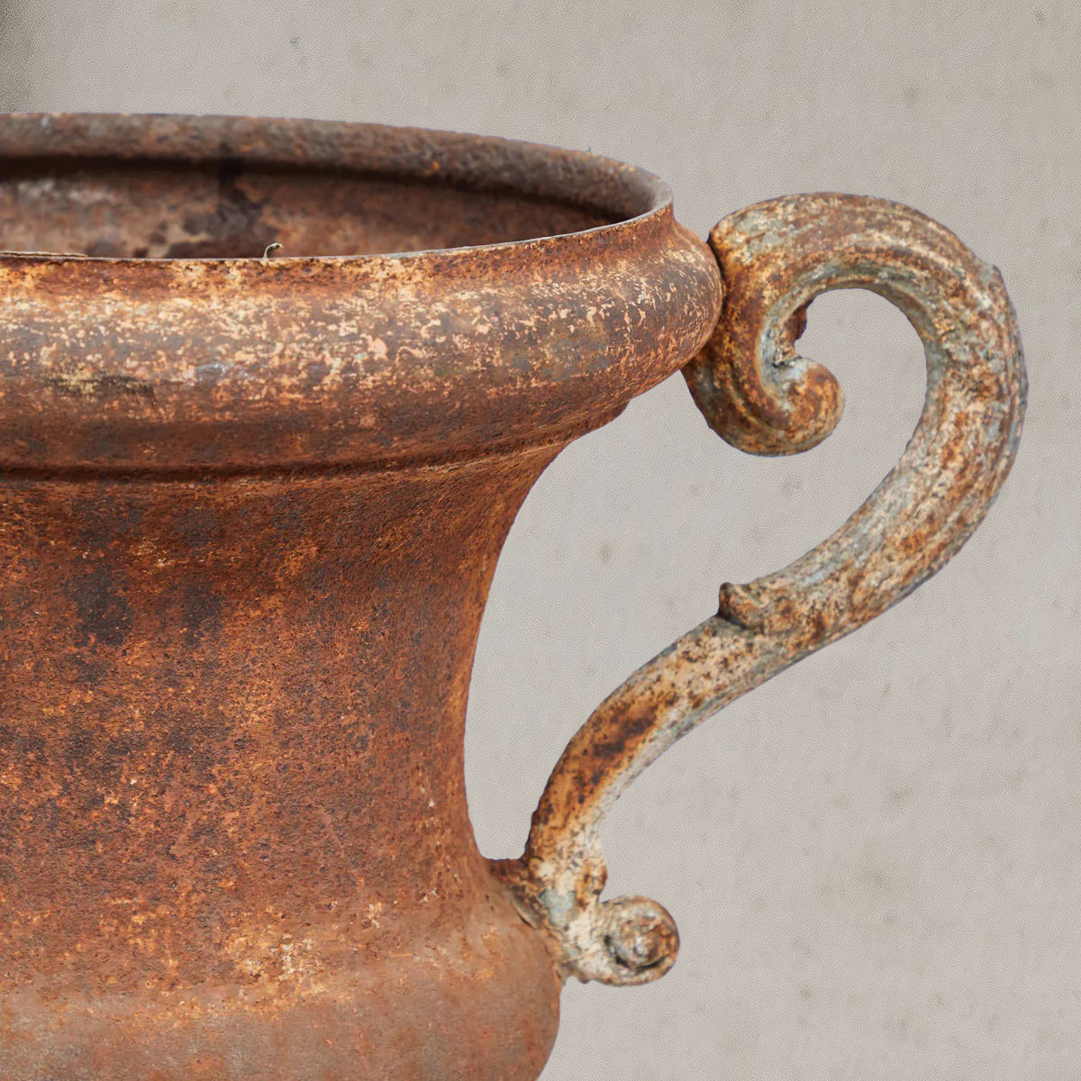 Pair of antique Italian iron urns with scrolled handles and rustic patina