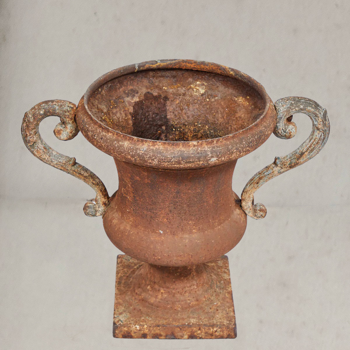 Pair of antique Italian iron urns with scrolled handles and rustic patina