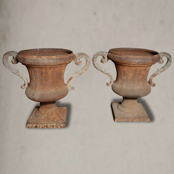 Pair of antique Italian iron urns with scrolled handles and rustic patina