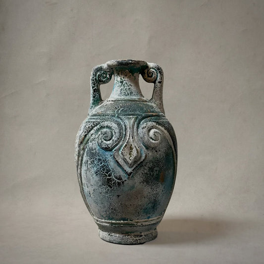 Vintage ceramic vase with decorative patterns on a plain background Mexican terracotta vessel with spiral handles and aged verdigris patina, circa 1980