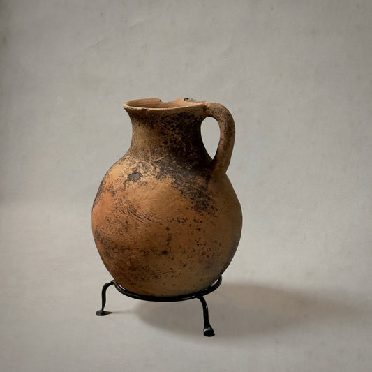 Vintage terra-cotta vessel with handle and mossy patina on metal stand