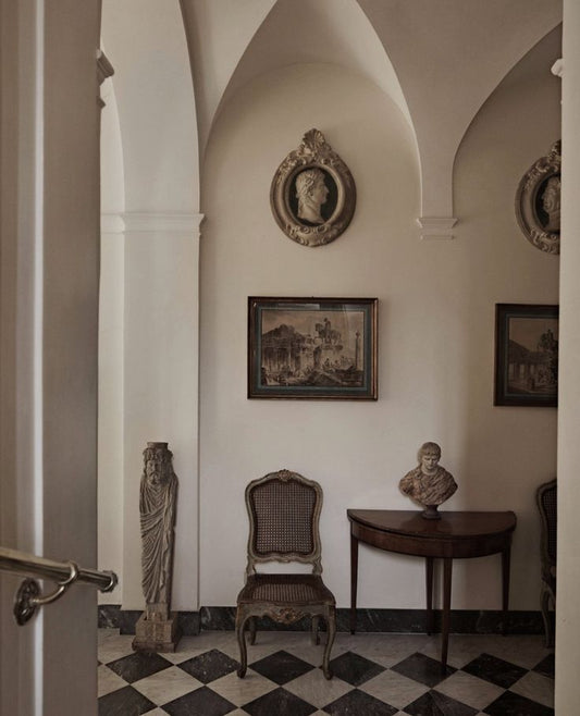 European dining room with classical columns, detailed molding, antique furniture, and natural light.