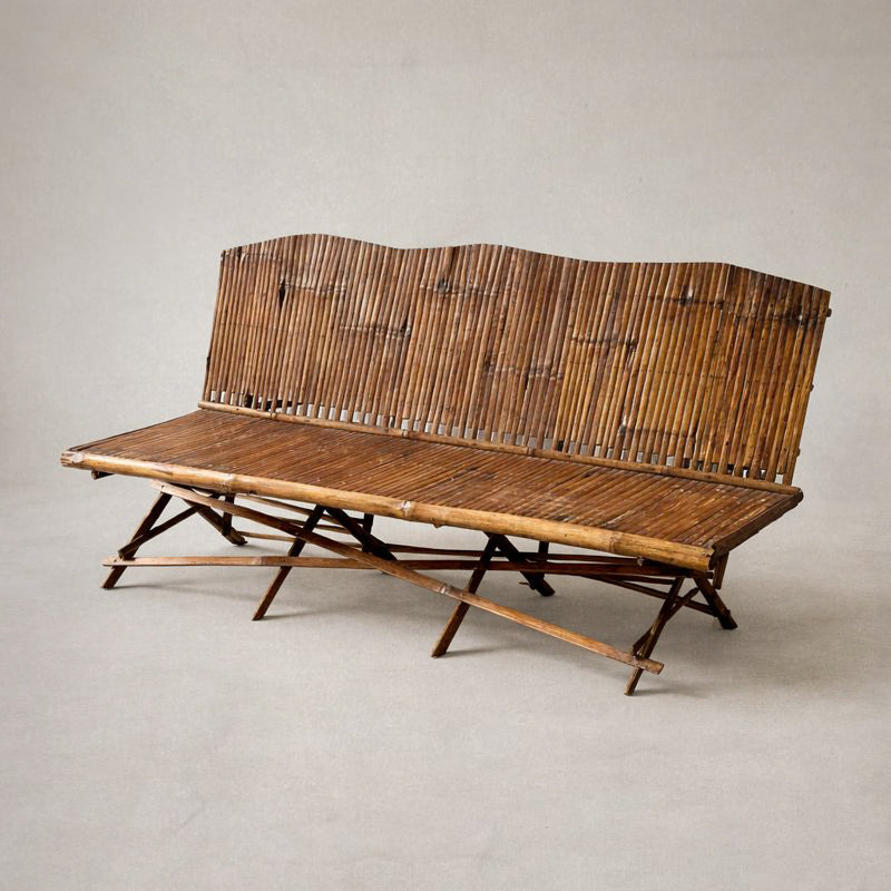 1920s English bamboo bench with slatted back and seat, shown against a soft neutral background, highlighting warm patina and folding base structure. right side view