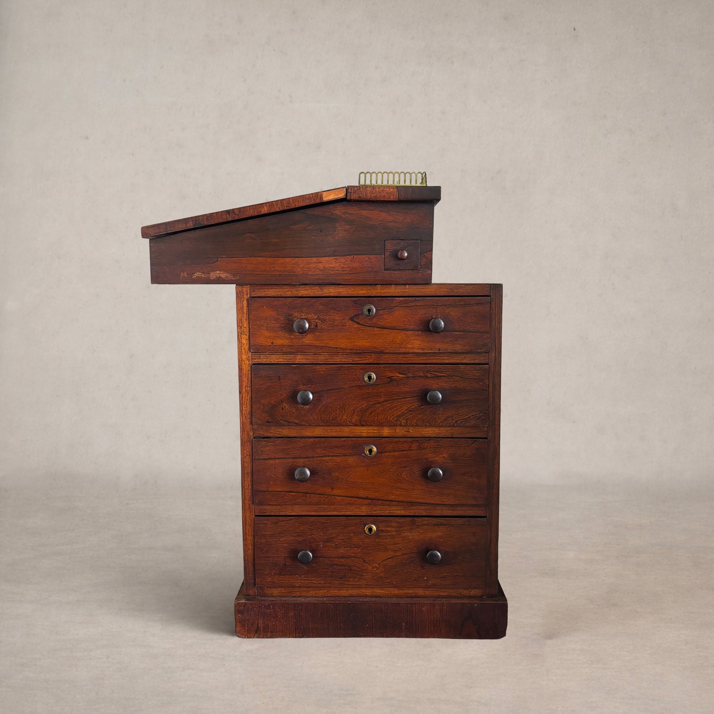 Antique slant-top desk opened to reveal interior compartments and small drawers with original hardware