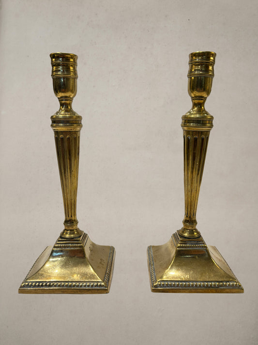 Pair of Georgian brass candlesticks with fluted columns and beaded square bases