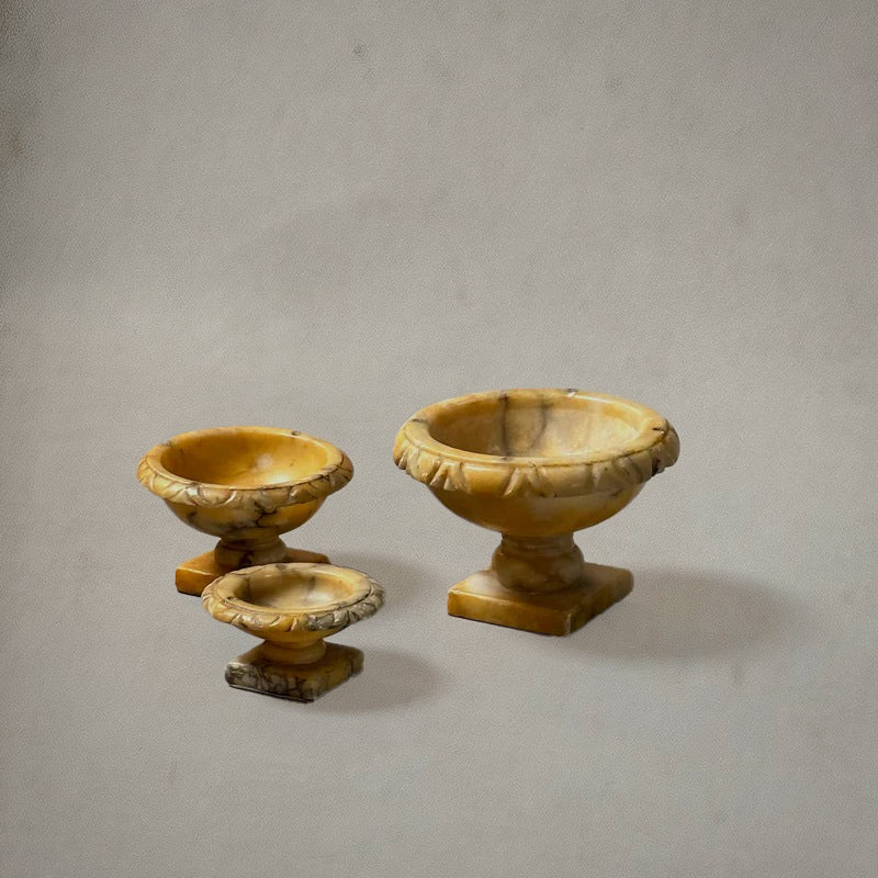 Set of three Italian alabaster tazzas with carved egg-and-dart rims and pedestal bases, circa 1750