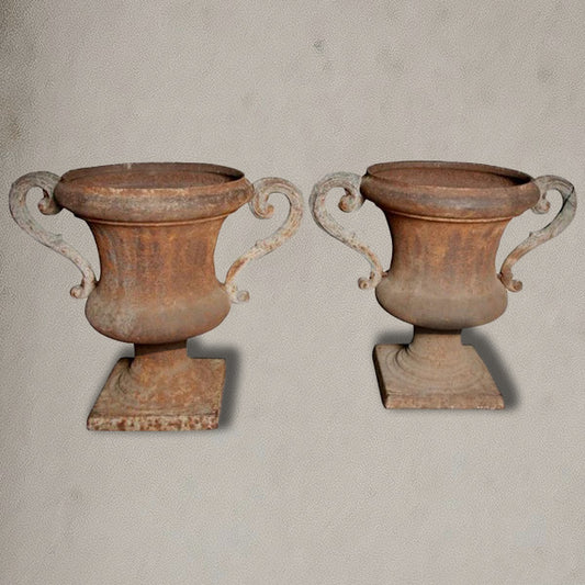 Pair of antique Italian iron urns with scrolled handles and rustic patina
