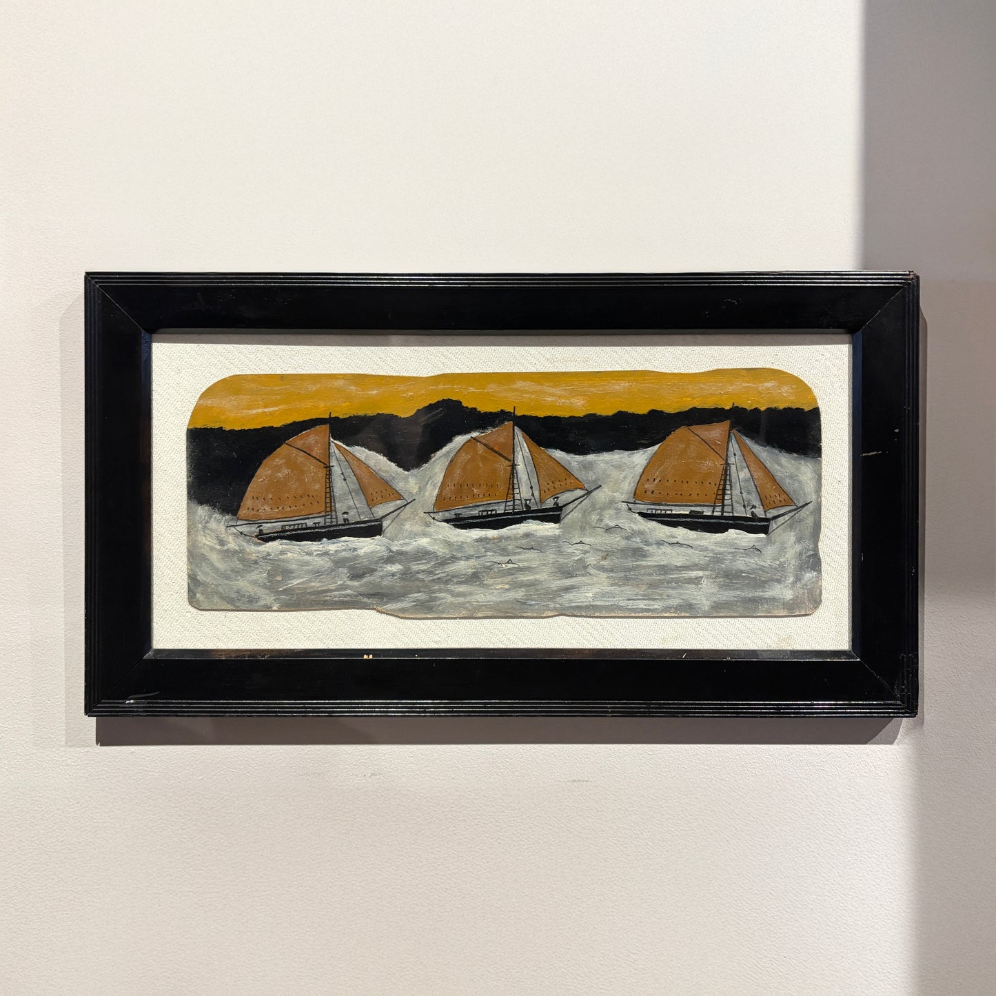 Wide folk-style maritime painting by Max Wildman showing three sailboats at sea in a black frame