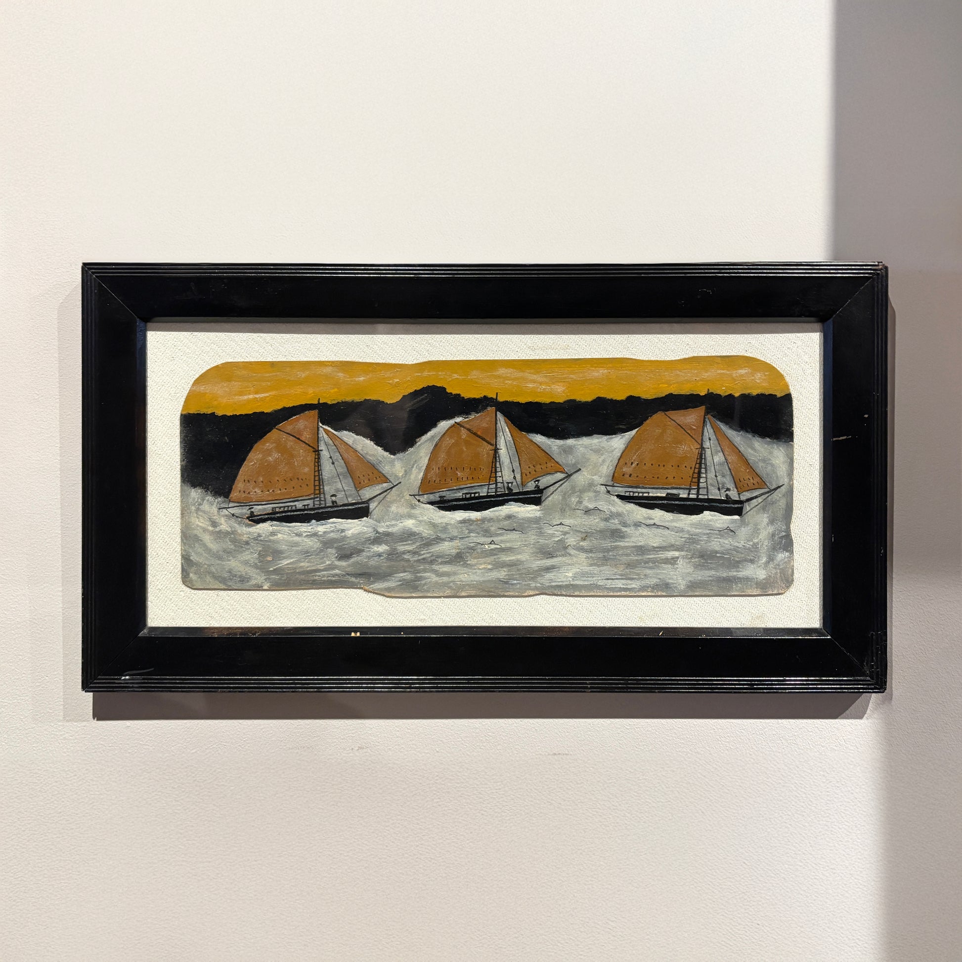Wide folk-style maritime painting by Max Wildman showing three sailboats at sea in a black frame