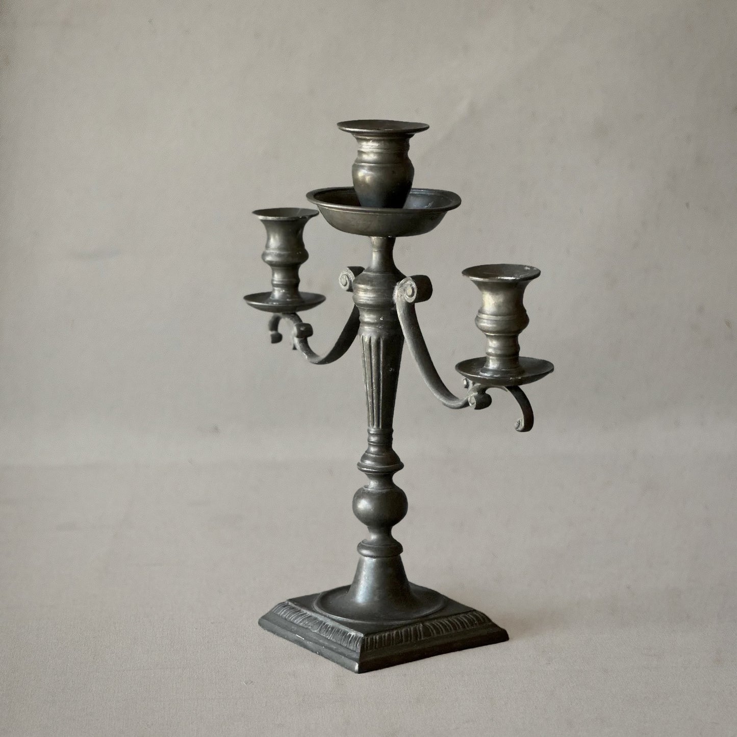English pewter three-arm candelabra with fluted stem and scroll arms, circa 1840, left
